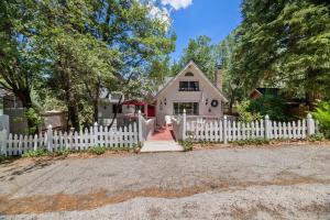 una cerca blanca frente a una casa blanca en Gnome Chalet - Charming Big Bear country home! Amazing craftsmanship and with a Fenced Yard!, en Big Bear Lake