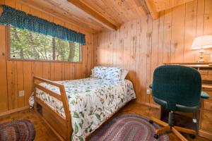 1 dormitorio con cama, escritorio y silla en Gnome Chalet - Charming Big Bear country home! Amazing craftsmanship and with a Fenced Yard!, en Big Bear Lake