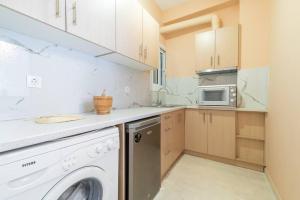 雅典的住宿－Modern African-inspired flat，厨房配有洗衣机和微波炉。