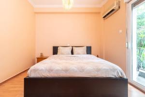 雅典的住宿－Modern African-inspired flat，一间卧室设有一张床和一个大窗户