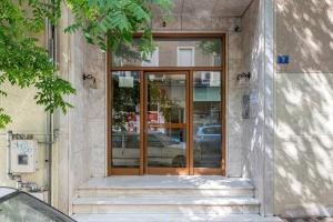 a glass door of a building with stairs at Modern African-inspired flat in Athens
