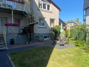 a house with a patio with a bike parked in the yard at Rest in Palanga in Palanga