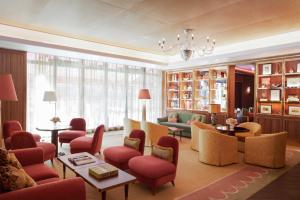 uma grande sala de estar com cadeiras e mesas e um lustre em Hotel Barrière Fouquet's New York em Nova York