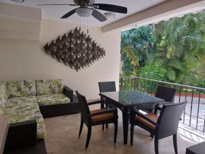 Una sala de estar con una mesa y sillas y un sofá. en Villas Cozumel #4, en Cozumel