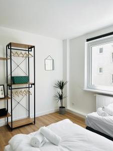 een slaapkamer met 2 bedden en een boekenplank bij Sali - R4 - Apartmenthaus, WLAN, TV in Remscheid