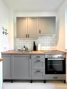 een keuken met witte kasten en een fornuis met oven bij Sali - R4 - Apartmenthaus, WLAN, TV in Remscheid