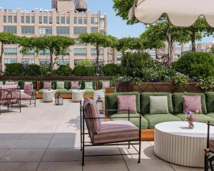 紐約的住宿－Hotel Barrière Fouquet's New York，庭院设有绿色和粉红色的椅子和桌子