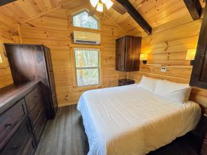 a bedroom with a bed in a wooden cabin at BMV4 Tiny Home with sleeping loft in Twin Mountain