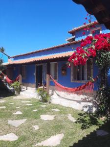 una casa azul con banderas rojas delante de ella en Casa Azul-Paraíso em Búzios, en Búzios