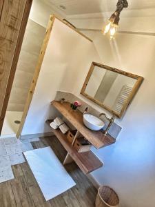 ein Bad mit einem Waschbecken und einem Spiegel in der Unterkunft U PASTURELLU in Pioggiola