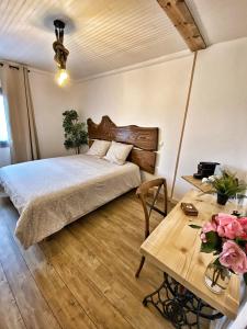 ein Schlafzimmer mit einem Bett und einem Tisch mit Blumen in der Unterkunft U PASTURELLU in Pioggiola