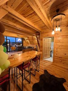 uma sala de jantar em madeira com uma grande mesa de madeira em Günışığı Bungalov em Rize