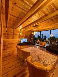 Günışığı Bungalov في ريزي: غرفة خشبية كبيرة مع غرفة معيشة مع أثاث