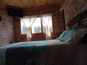 een slaapkamer met een groot bed en een raam bij Hermosa cabaña en zacatlan puebla la escondida in Jicolapa