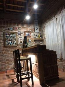 een kamer met een bakstenen muur, een open haard en 2 stoelen bij Hermosa cabaña en zacatlan puebla la escondida in Jicolapa