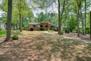 ein Haus im Wald mit großem Hof in der Unterkunft Liberty Lodge Lakefront Cottage with Porch and Dock in Eatonton