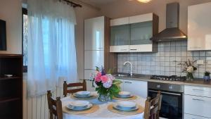 uma cozinha com uma mesa com pratos e flores em Apartments Villa Ida em Opatija