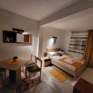 1 dormitorio con cama, escritorio y mesa en Apartmani Mia Sorajic, en Petrovac na Moru