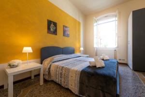 a bedroom with a bed and a yellow wall at Casa Pier - Centralissima in villa d'epoca in Rapallo