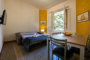 a bedroom with a bed and a table and a dining room at Casa Pier - Centralissima in villa d'epoca in Rapallo