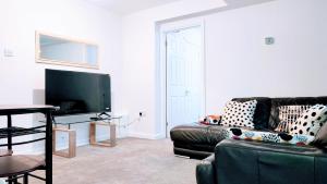 uma sala de estar com um sofá e uma televisão de ecrã plano em 1 Bedroom Annex - Close to Frimley Hospital - Private Entrance em Frimley