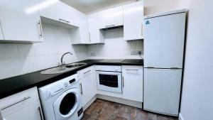 cocina blanca con fregadero y nevera en 1 Bedroom Annex - Close to Frimley Hospital - Private Entrance en Frimley