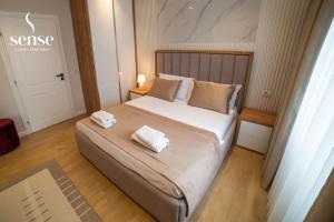 a bedroom with a large bed with two towels on it at Sense Luxury Apartments in Velipojë