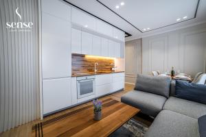 a living room with a couch and a kitchen at Sense Luxury Apartments in Velipojë