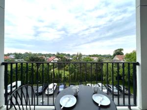 a balcony with a table and chairs and a view of a parking lot at Zarembowicza A36 Apartment - Self Check-In 20h - Parking &Lift in Wrocław