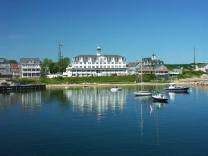 um grupo de barcos na água em frente a um grande edifício em National Hotel em New Shoreham