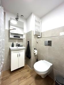 a bathroom with a white toilet and a sink at Zarembowicza A36 Apartment - Self Check-In 20h - Parking &Lift in Wrocław