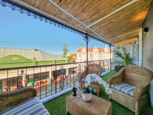 een patio met 2 stoelen en een tafel op een balkon bij Contemporary and Stylish Apartment in Observatory in Kaapstad