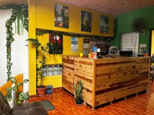 a restaurant with a wooden counter and yellow walls at Casa Maya Itza in Flores