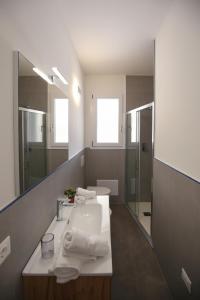 ein Bad mit einem Waschbecken und einem Spiegel in der Unterkunft Appartamento Casa vacanza Le Terrazze Via Parigi,23 in Castelsardo