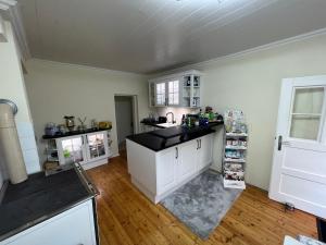 a kitchen with white cabinets and a black counter top at Meli´s Zirbenbett Ferienhaus in Bernstein