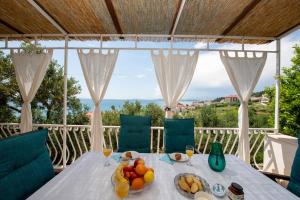 a table with a bowl of fruit on a balcony at Holiday Home Andrija in Podstrana