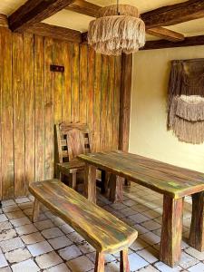 une table et un banc en bois dans une chambre avec un lustre dans l'établissement Едем, à Brzezhany