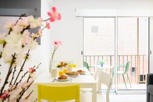 Un comedor blanco con una mesa blanca y sillas amarillas. en New apartment city & sea - 3 bedroom - by 10toSea, en Fuengirola