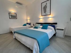 a hotel room with two beds with blue pillows at Casa Vanni in Vada
