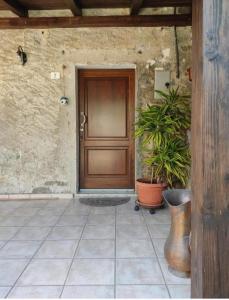 uma porta da frente de uma casa com vasos de plantas em Casa vacanze Alloro em Mangia