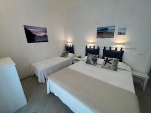 a hotel room with two beds and paintings on the wall at Casa Vanni in Vada
