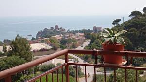 una maceta sentada en un balcón con vistas a la ciudad en Carmen Suite, en Cefalú