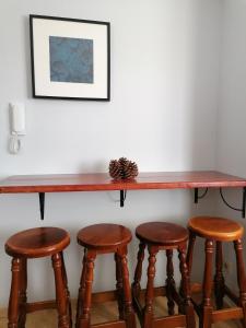 einen Tisch und vier Hocker unter einer Theke in der Unterkunft Amber House in Arinaga