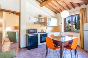 Lupompesi的住宿－Appartamenti le Ginestre，厨房配有木桌和橙色椅子