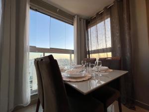 uma mesa de jantar com copos de vinho e uma janela em ITAPARICA RELAX INN! Portaria e bar 24H! em Vila Velha