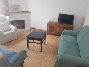 uma sala de estar com um sofá, uma mesa e uma televisão em Casa de los Valles en RioNansa em Puentenansa