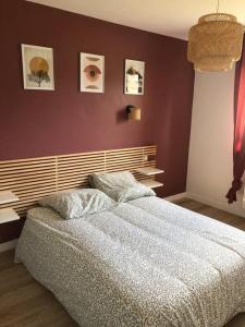 um quarto com uma cama grande e uma parede com fotografias em Maison Neuve à St-Thégonnec em Saint-Thégonnec