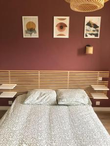um quarto com uma cama e uma parede com fotografias em Maison Neuve à St-Thégonnec em Saint-Thégonnec