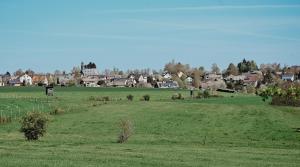 um campo de relva verde com uma cidade ao fundo em Ferienwohnung Landblick 