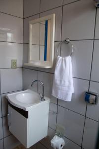 baño con lavabo, espejo y toalla en Casa com piscina e churrasqueira em Lagoa Santa MG en Lagoa Santa